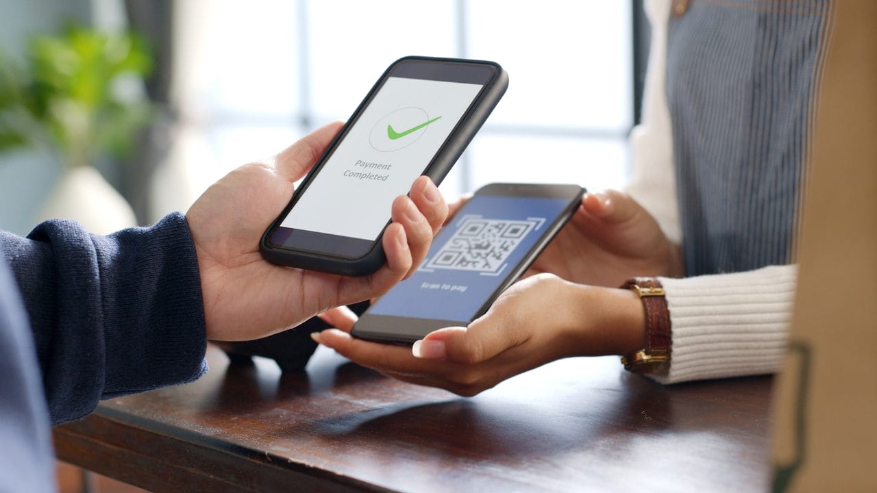 Customer making a contactless payment using a smartphone and payment terminal