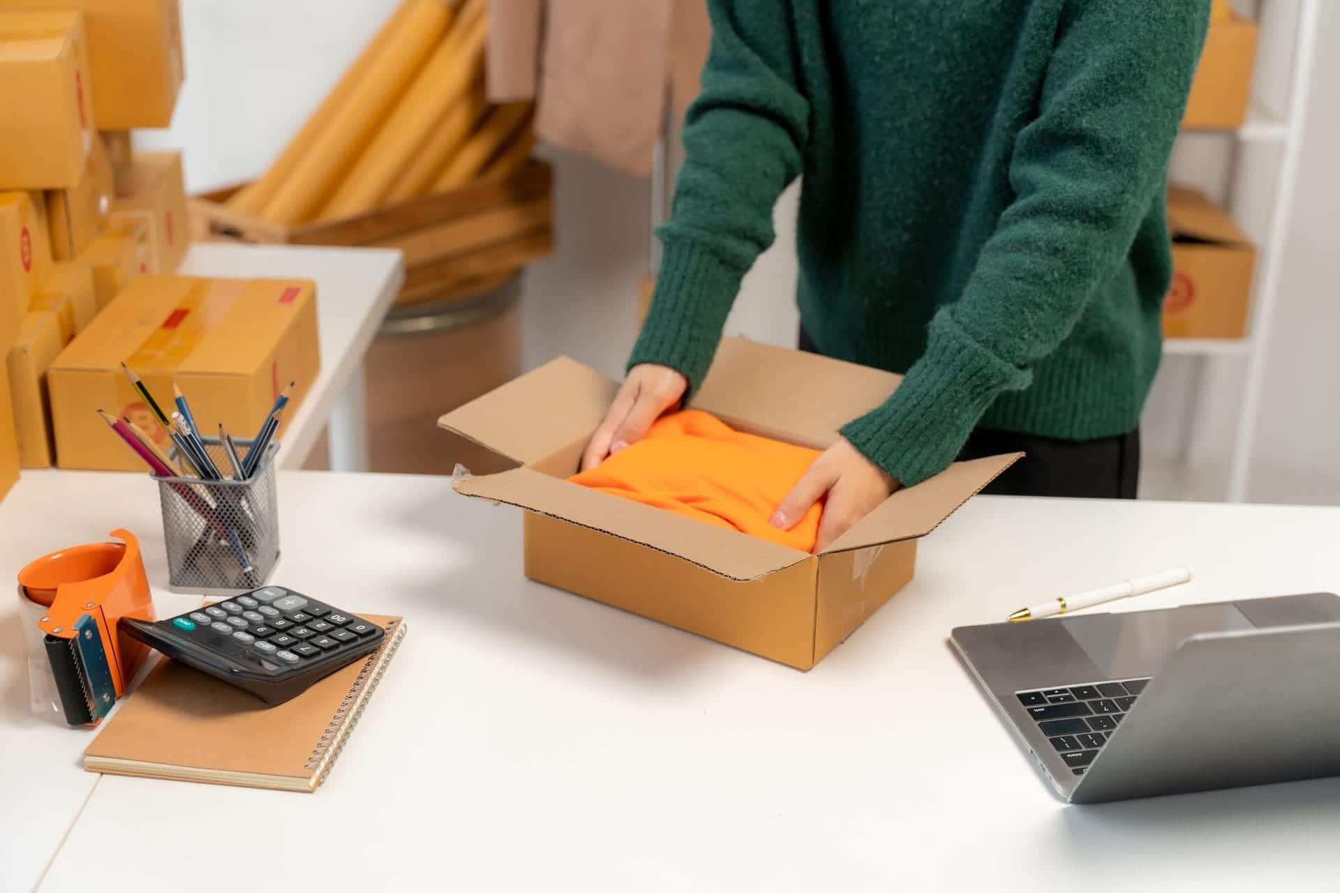 Person packing an online order into a cardboard box