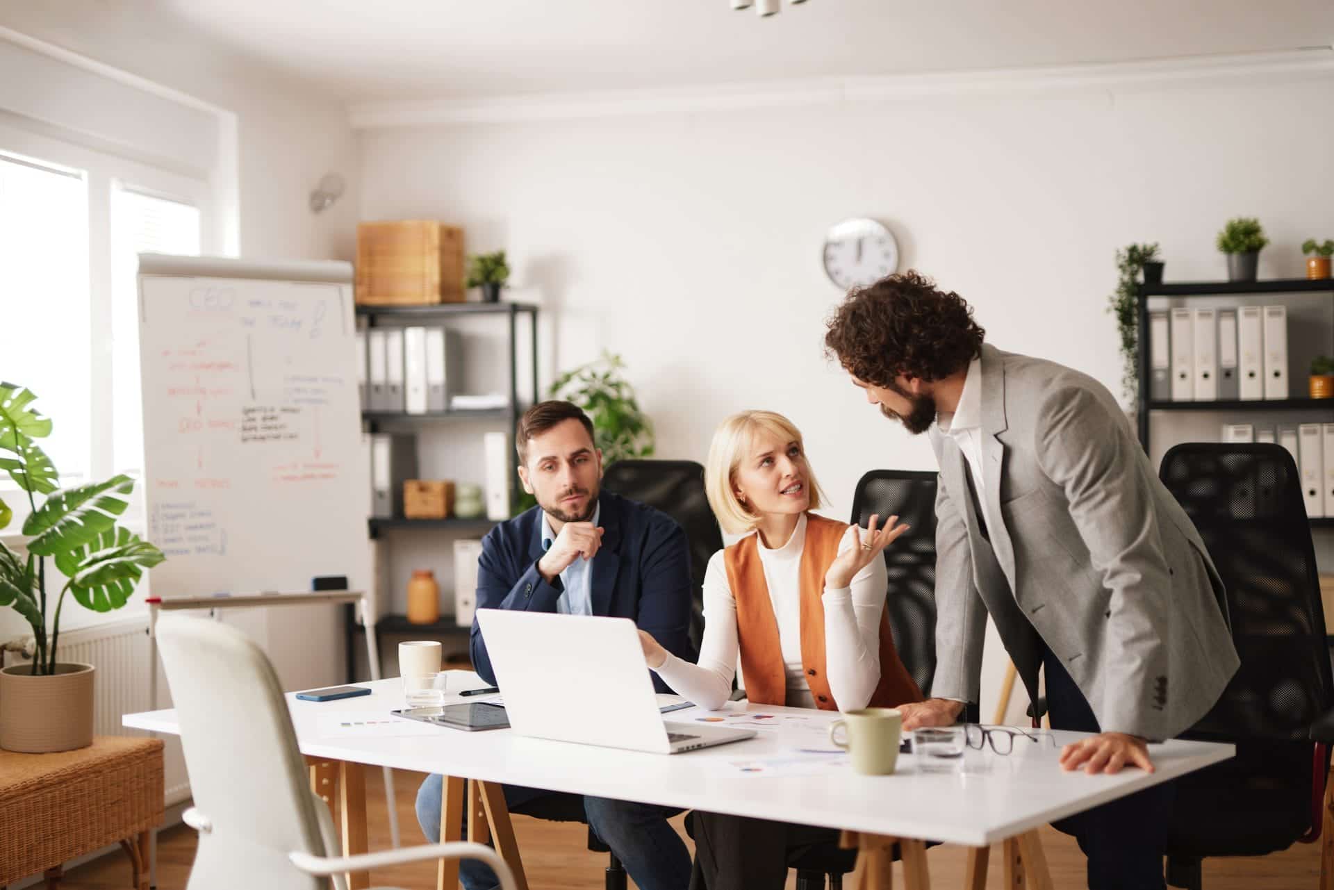 Business team collaborating around laptops in an office